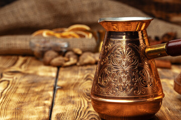 Shiny copper turk with brewed coffee on brown wooden table