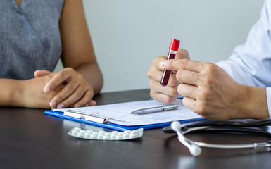 The doctor took the blood sample and explained the results of the blood test of the patient on the...