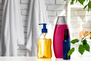 Cosmetic bottles against white bathroom wall background
