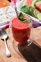 Watermelon smoothie garnished with fresh mint leaves - refreshing drink ideal for hot summer days.