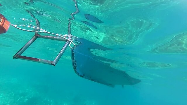 a boat in the water filmed by an underwater camera