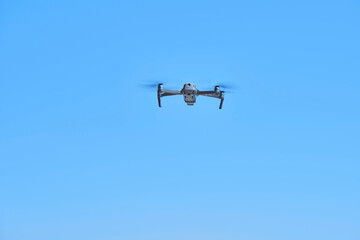 青空を飛行する小さなドローン