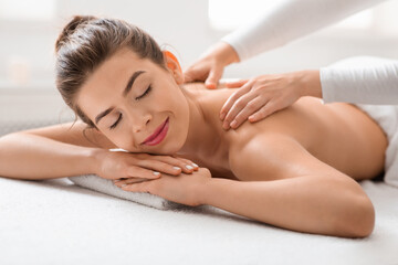 Fototapeta na wymiar Peaceful woman getting relaxing back massage at spa