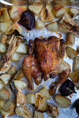 Cooking whole roasted crispy skin chicken with new potatoes, lemon, onions, garlic