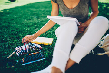Smiling female using stationary for making illustration for planning sitting in university...