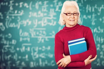 Smile woman teacher with books on blackboard background