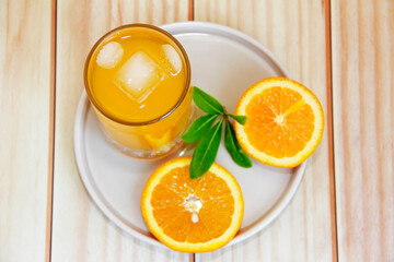 orange drink in a glass and slices of natural orange