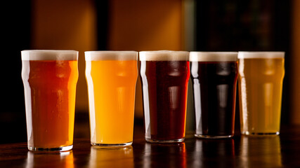 Beer mix in pub. Dark, light, barley, lager and ale in glasses on brown wooden bar counter