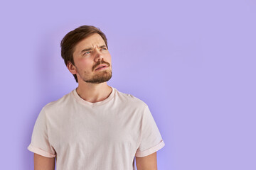 Fototapeta premium portrait of puzzled and confused man with beard in casual wear, thoughtful, not knowing what is wrong. human feeling, emotions, face expressions