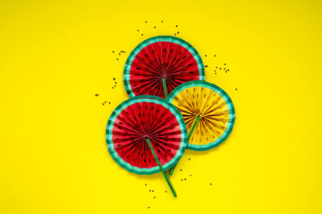 Paper fruit origami watermelon fan decoration top view on bright yellow background. Tropics summer