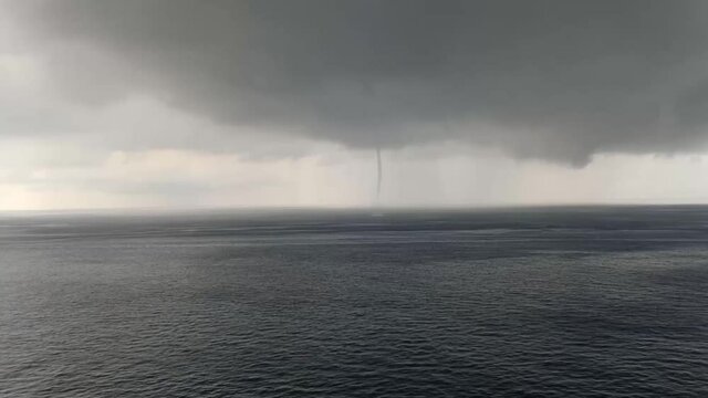 waterspout in ocean and cloudy sky