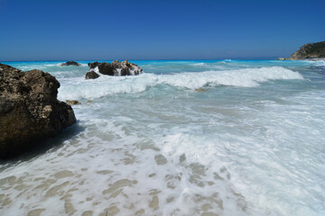 Fototapeta na wymiar Rocks in shallow water splashed with waves