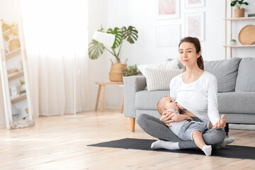 Relaxed Young Mother Meditating While Breastfeeding Her Baby At Home, Practicing Yoga