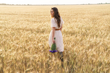 Photo of beautiful happy woman smiling while walking on wheat field