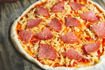 Salami Pizza raw  close up on stainless board before Into the oven