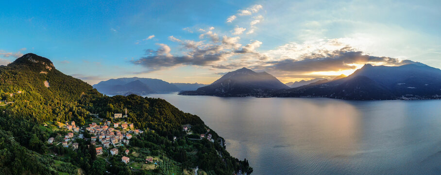 beautiful aerial panorama of village by lake como italy during sunset light with lake and mountains in background