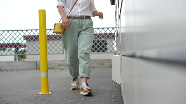 The girl in the protective mask takes the parcel from the postamat. Contactless delivery, online shopping