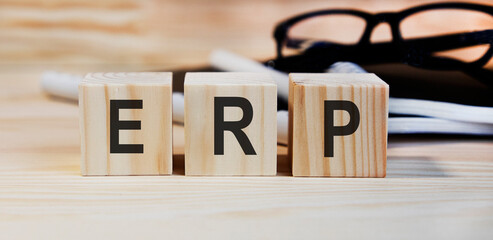 On wooden cubes the inscription ERP, in the background of the book and glasses.