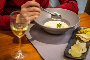 cheese soup with turkey fillet .A glass of white wine. restaurant food. author menu. Delicious homemade food. Croutons on the White Boards