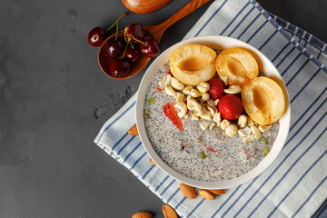 Bowl of chia poudding with pieces of apricots and strawberry