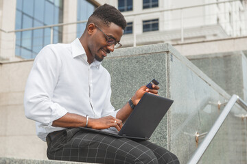 Businessman using credit card and laptop at home office