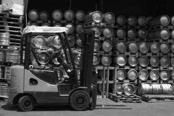 Obraz na płótnie Canvas Metal barrel. Keg with beer. A large number. Stock. Logistics and alcohol concept. Wooden pallets. Black and white. Car loader