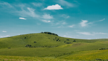 Fototapeta na wymiar Green hills and cloudy sky
