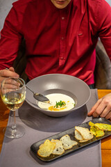 cheese soup with turkey fillet .A glass of white wine. Croutons on the White Boards. restaurant food. author menu. Delicious homemade food