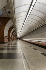 Empty metro station, lonely people on long platform.