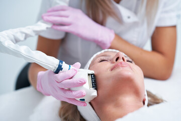 Adult woman in beauty salon undergoing face hydrogen purification