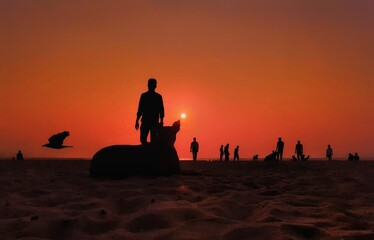 silhouette of a man sitting on the beach at sunset