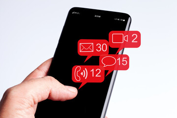 Male hand holding smartphone in isolated white background social networks and flying notification icons
