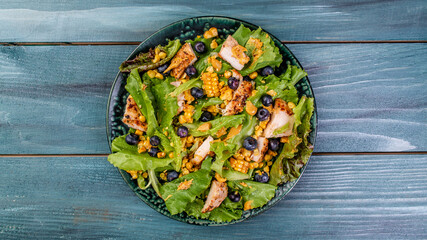 Fresh Tasty blueberries salad with chicken fillet, green vegetables and mustard. healthy food. banner, catering menu recipe place for text, top view