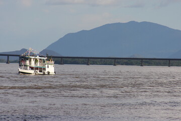 Barco no rio Branco com ponte dos Macuxis e Serra Grande ao fundo 