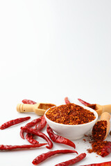 Cayenne pepper in a white cup with many red dried chilies.