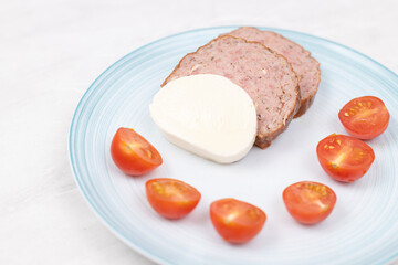 Sliced Meatloaf served with cheese and cherry tomatoes