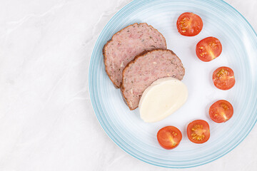 Sliced Meatloaf served with cheese and cherry tomatoes