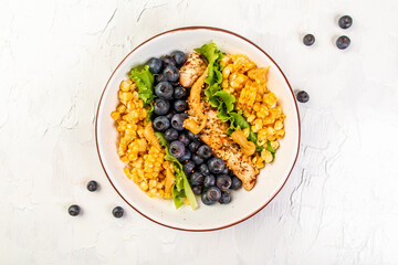 Ketogenic diet breakfast. Chicken salad with corn, lemon, mustard blueberries. Keto paleo lunch. Top view
