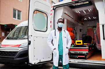 African male paramedic in face protective medical mask standing in front of ambulance car. © AS Photo Family