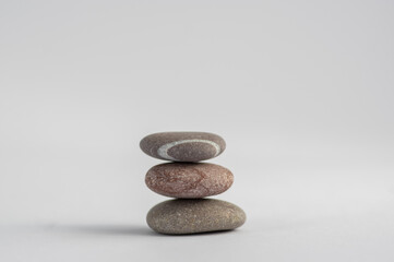 Fototapeta na wymiar One simplicity stones cairn isolated on white background, group of light three gray white pebbles built in tower