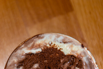 A close-up high angle view of a small bucket of melting chocolate ice cream with a spoon 