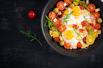 English breakfast - fried eggs, ham, tomatoes and arugula. American food. Top view, overhead, copy space