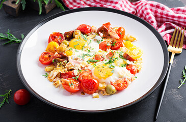 English breakfast - fried eggs, ham, tomatoes and arugula. American food.