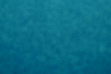 bluish-green bokeh effect background with light falling on it