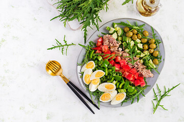 Healthy food. Tuna fish salad with eggs, cucumber, tomatoes, olives and arugula.  French cuisine. Top view, copy space, flat lay