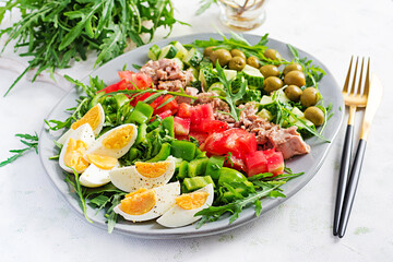 Healthy food. Tuna fish salad with eggs, cucumber, tomatoes, olives and arugula.  French cuisine.