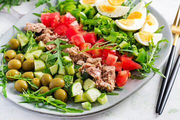 Healthy food. Tuna fish salad with eggs, cucumber, tomatoes, olives and arugula.  French cuisine.