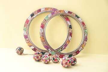 Indian traditional multi-color rhinestone type imitation bangles with hangings to the bangles.