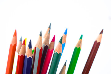 Huge pile of different colored wood pencil crayon placed on a white background