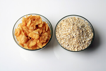 Bowl full of oats and corn flakes. Porridge oats in cereal bowl and corn flakes on white background. Healthy Eating concept-Oat Flakes and corn flakes.